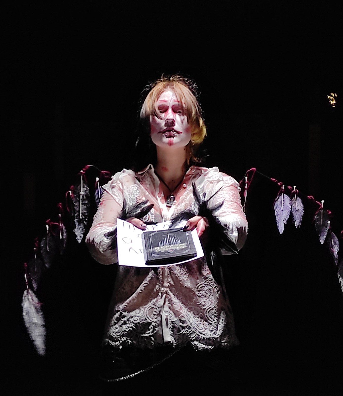 Dark portrait of the angel character with white face paint