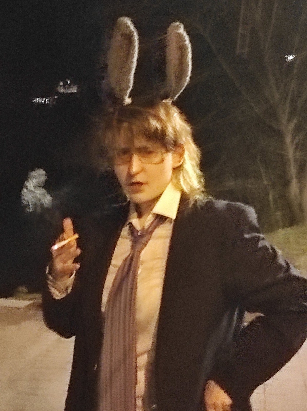 Person in a suit and bunny ears hiding their face