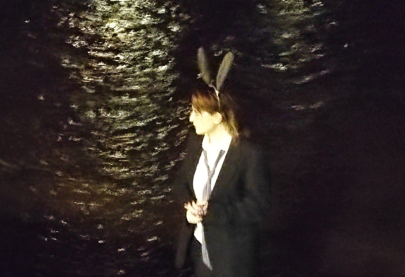Bunny character in a suit standing by dark water